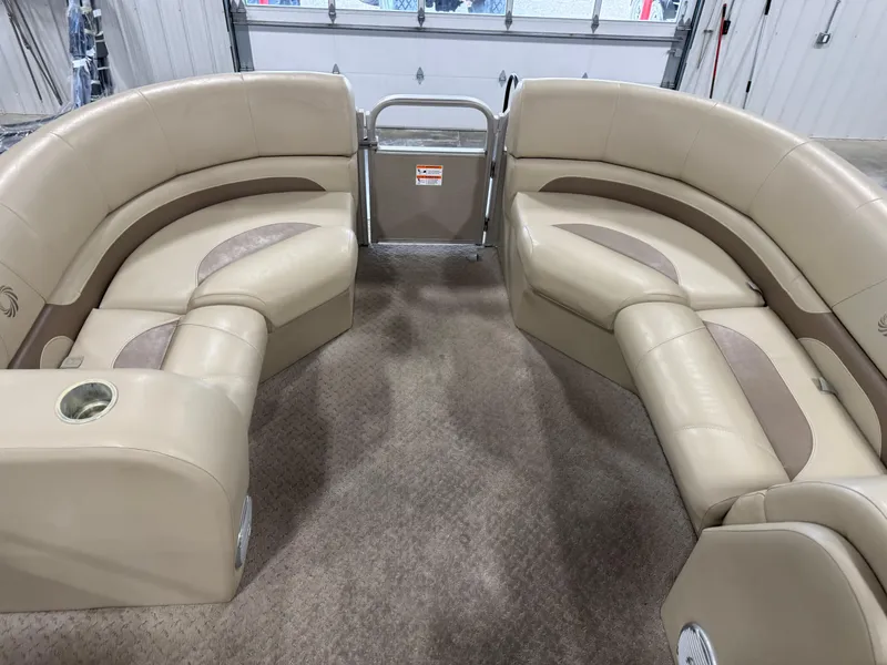 Slide: The Image of 2015 Lowe 210 SS pontoon boat interior with beige seating and carpeted floor. - 11