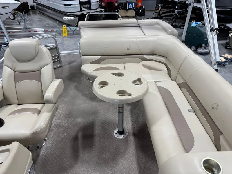 Slide: The Image of 2015 Lowe 210 SS pontoon boat interior with beige seating and table. - 12