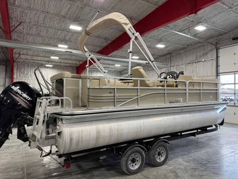 Slide: The Image of 2015 Lowe 210 SS pontoon boat on trailer in indoor storage facility. - 3