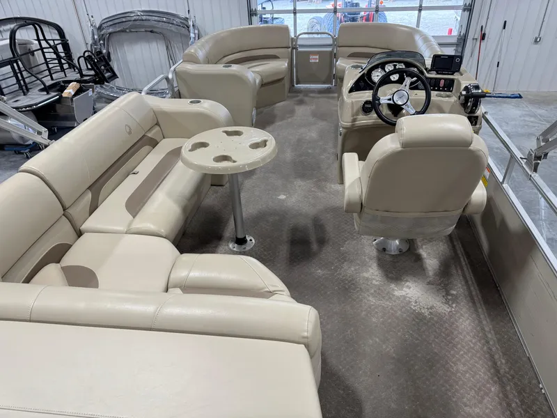 Slide: The Image of 2015 Lowe 210 SS pontoon boat interior with beige seating and steering console. - 6