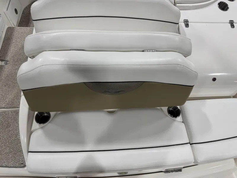 Slide: The Image of 2012 Rinker 296 Captiva Bowrider interior seating with white upholstery and cup holders. - 11