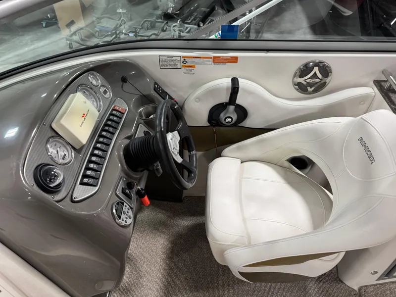 Slide: The Image of 2012 Rinker 296 Captiva Bowrider cockpit with steering wheel and control panel. - 12