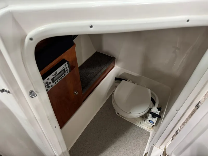 Slide: The Image of 2012 Rinker 296 Captiva Bowrider interior with compact marine toilet and control panel. - 13
