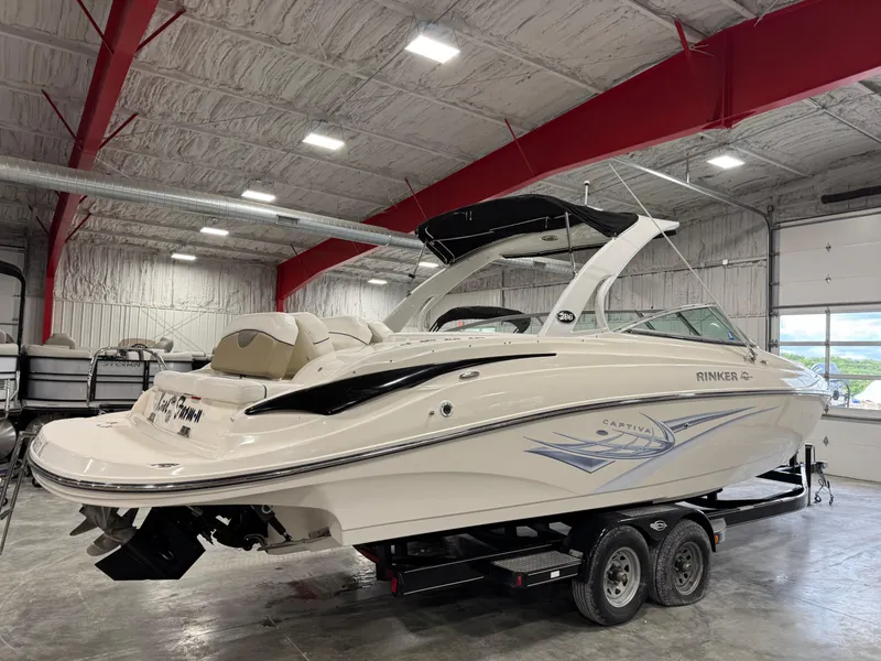 Slide: The Image of 2012 Rinker 296 Captiva Bowrider boat in a spacious indoor storage facility. - 4