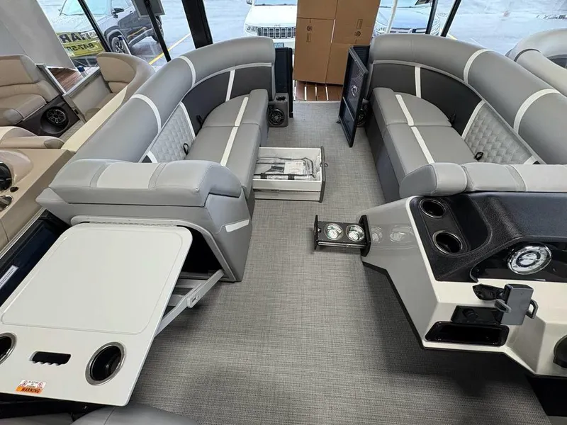 Slide: The Image of 2025 Crest Classic 220 SLSC Tritoon interior with gray seating and modern amenities. - 3