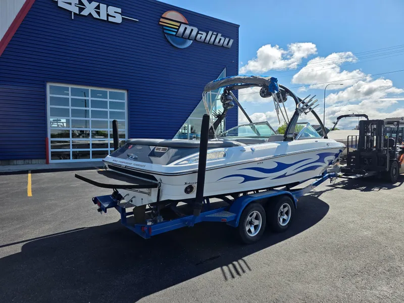 Slide: The Image of 2007 Centurion Boats ENZO23 on trailer outside dealership, blue and white design. - 9