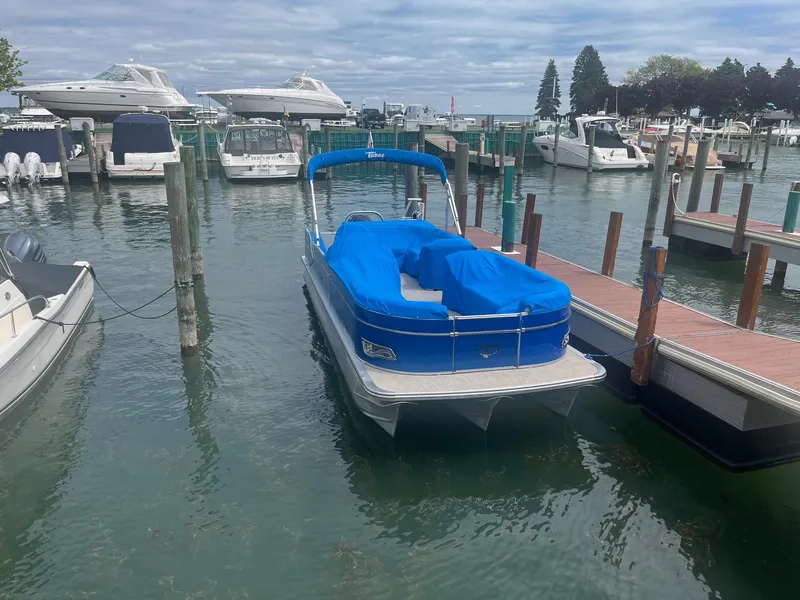 Slide: The Image of 2018 Tahoe Cascade 2585 CR pontoon boat docked in a marina with blue cover. - 15