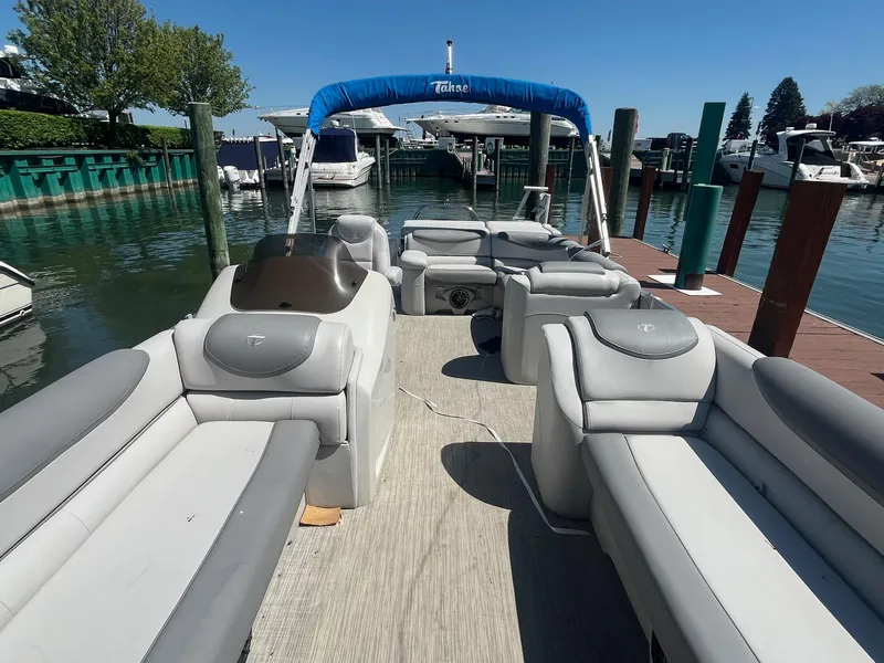 Slide: The Image of 2018 Tahoe Cascade 2585 CR pontoon boat docked at marina, featuring spacious seating and canopy. - 2