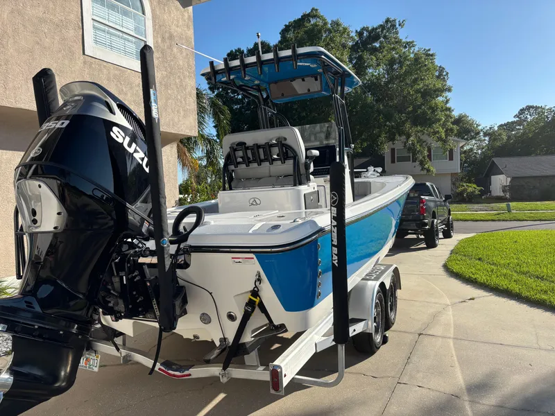 Slide: The Image of 2023 Blazer 2700 HYBRID BAY boat with Suzuki engine on a driveway. - 3