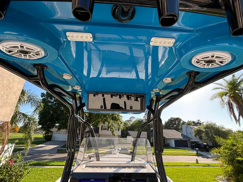 Slide: The Image of 2023 Blazer 2700 HYBRID BAY boat interior with blue ceiling, speakers, and rod holders. - 4