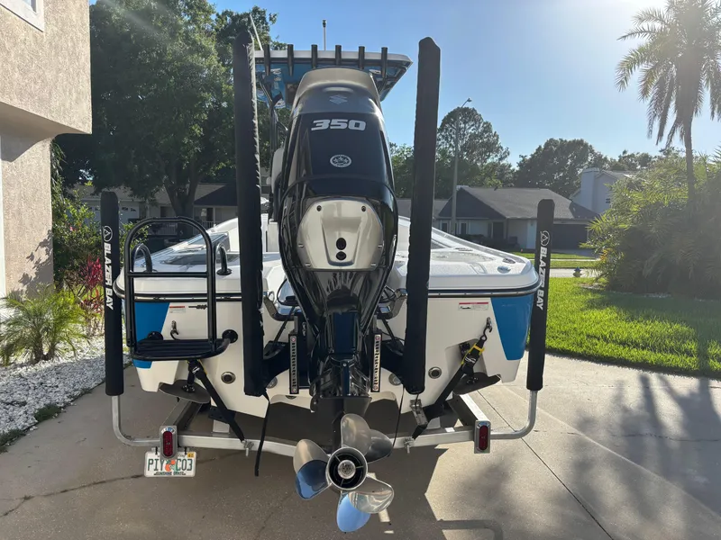 Slide: The Image of 2023 Blazer 2700 HYBRID BAY boat with powerful 350 engine, parked in a sunny driveway. - 9