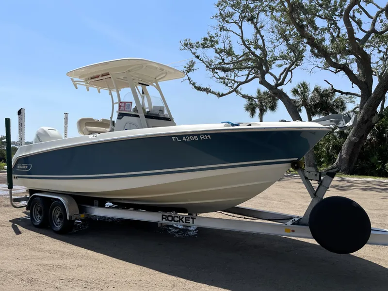 Slide: The Image of 2017 Boston Whaler 230 Outrage boat on trailer, parked outdoors. - 1