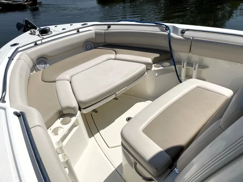 Slide: The Image of 2017 Boston Whaler 230 Outrage boat interior with cushioned seating and cup holders. - 10