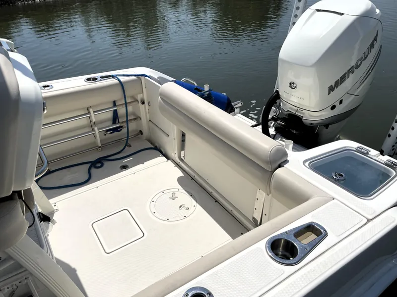 Slide: The Image of 2017 Boston Whaler 230 Outrage boat interior with Mercury engine, docked by water. - 15