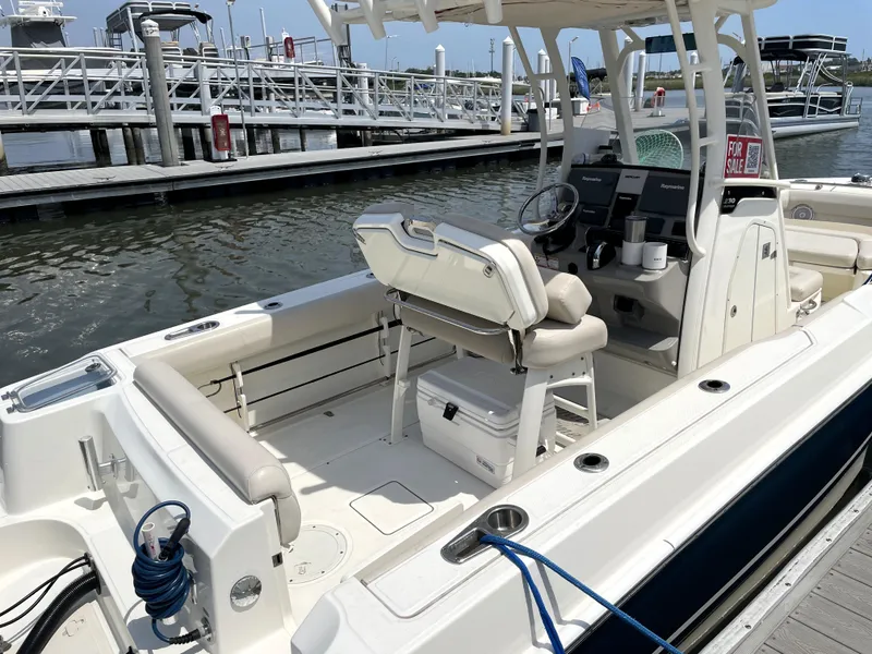 Slide: The Image of 2017 Boston Whaler 230 Outrage boat docked, featuring spacious seating and modern controls. - 16