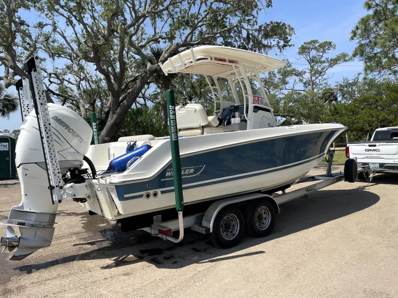 Slide: The Image of 2017 Boston Whaler 230 Outrage boat on trailer, parked outdoors. - 2
