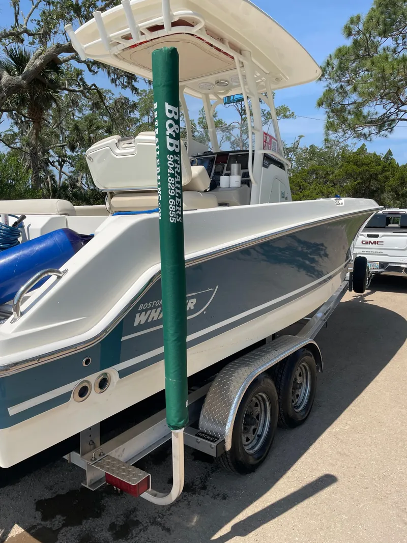 Slide: The Image of 2017 Boston Whaler 230 Outrage boat on trailer, parked outdoors. - 8