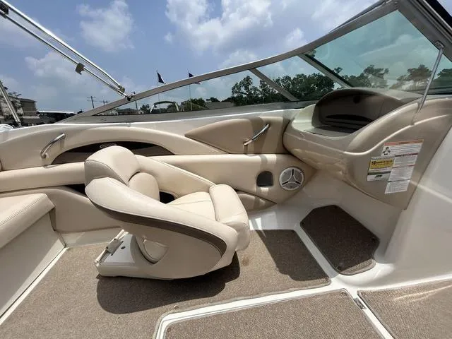 Slide: The Image of 2006 Chaparral 204 SSi boat interior with beige seating and dashboard under a clear sky. - 28