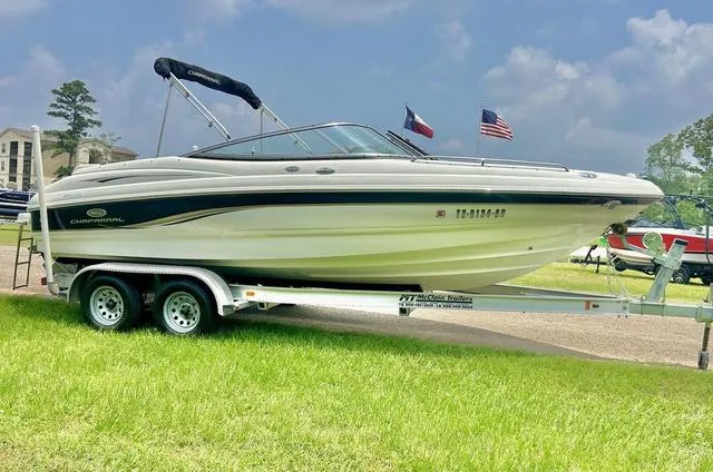 Slide: The Image of 2006 Chaparral 204 SSi boat on trailer, parked on grass, with flags in background. - 3