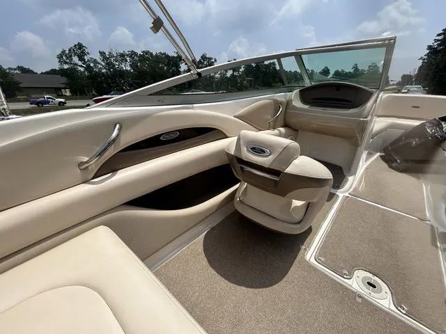 Slide: The Image of 2006 Chaparral 204 SSi boat interior with beige seating and dashboard under a clear sky. - 30