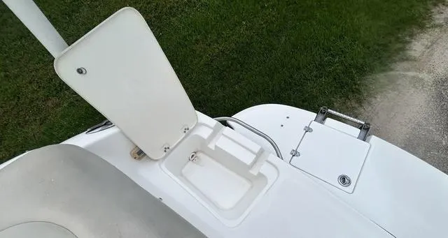 Slide: The Image of 2006 Chaparral 204 SSi boat with open storage compartment, grassy background. - 48