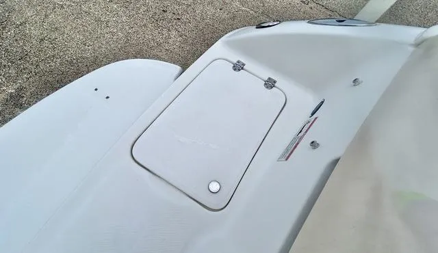 Slide: The Image of 2006 Chaparral 204 SSi boat deck with storage compartment and safety labels. - 49