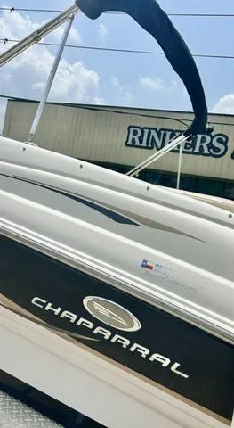 Slide: The Image of 2006 Chaparral 204 SSi boat near Rinker's building under blue sky. - 6