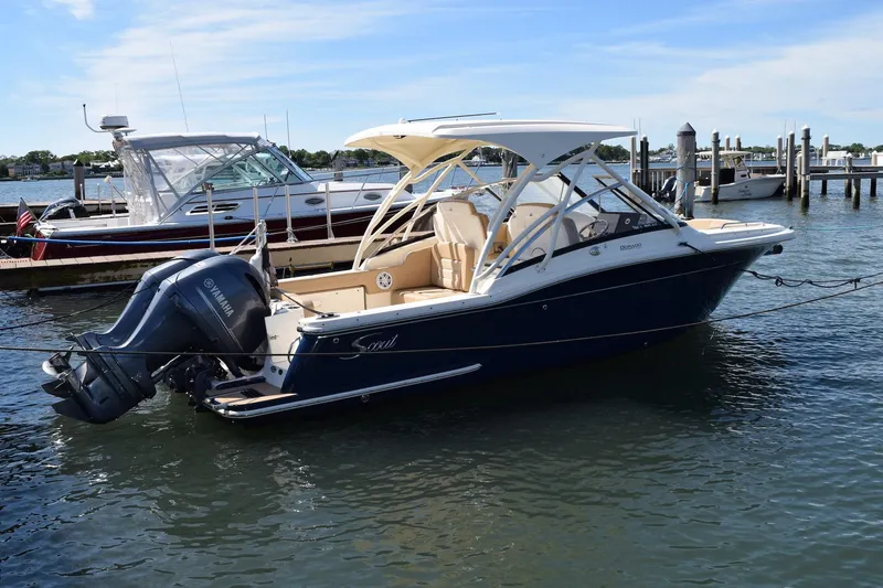 Slide: The Image of 2020 Scout 255 Dorado boat docked in marina, featuring dual outboard engines. - 0
