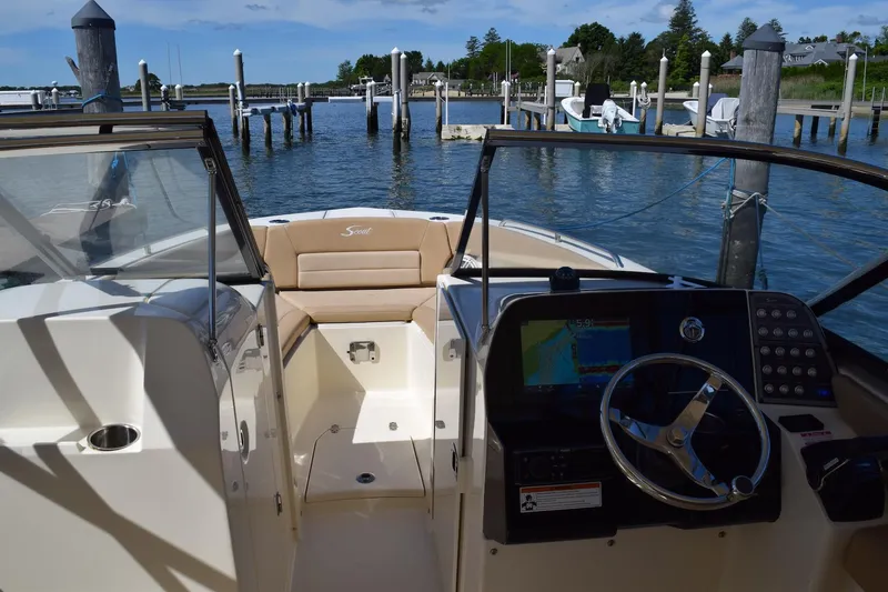 Slide: The Image of 2020 Scout 255 Dorado boat interior with steering wheel, docked at marina. - 12