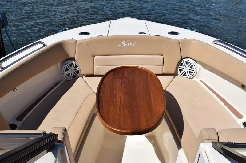 Slide: The Image of 2020 Scout 255 Dorado boat interior with cushioned seating and wooden table. - 13