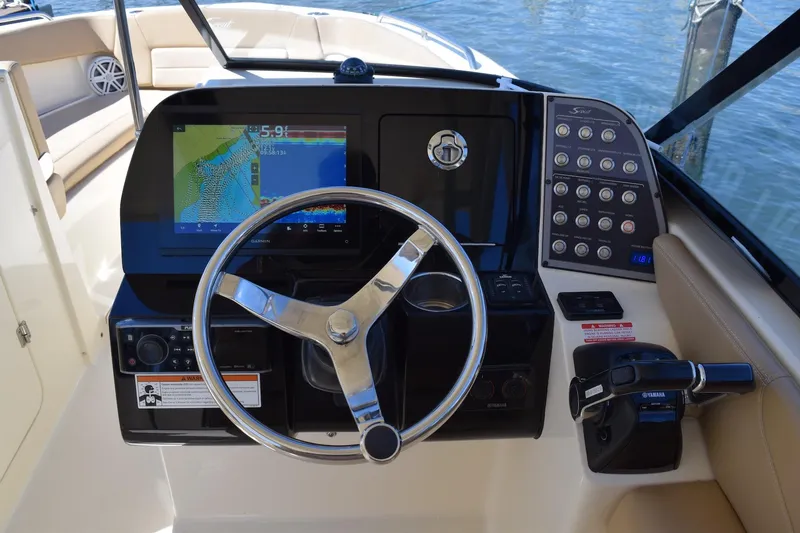 Slide: The Image of 2020 Scout 255 Dorado boat dashboard with steering wheel and navigation display. - 16