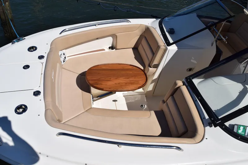 Slide: The Image of 2020 Scout 255 Dorado boat with beige seating and wooden table in the cockpit area. - 18
