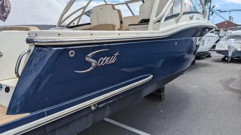 Slide: The Image of 2020 Scout 255 Dorado boat, blue hull, parked in marina. - 4