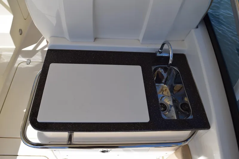 Slide: The Image of 2020 Scout 255 Dorado boat kitchenette with sink and cutting board. - 8