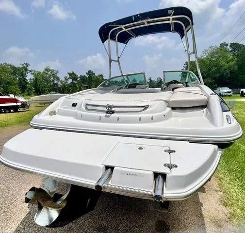 Slide: The Image of 2005 Crownline 216 LS boat with canopy, rear view, parked outdoors on a sunny day. - 10