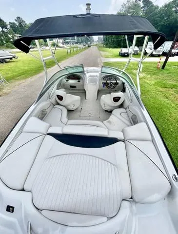 Slide: The Image of 2005 Crownline 216 LS boat with canopy, white interior, parked on grass. - 12