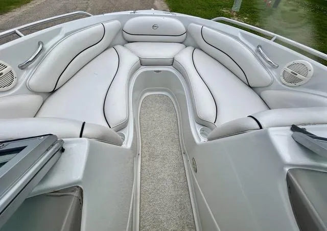 Slide: The Image of 2005 Crownline 216 LS boat interior with white cushioned seating and carpeted floor. - 13