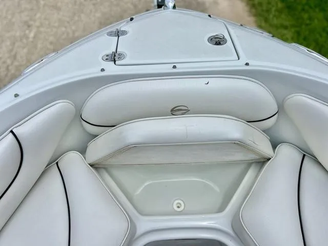 Slide: The Image of 2005 Crownline 216 LS boat interior with white cushioned seating and storage compartments. - 17