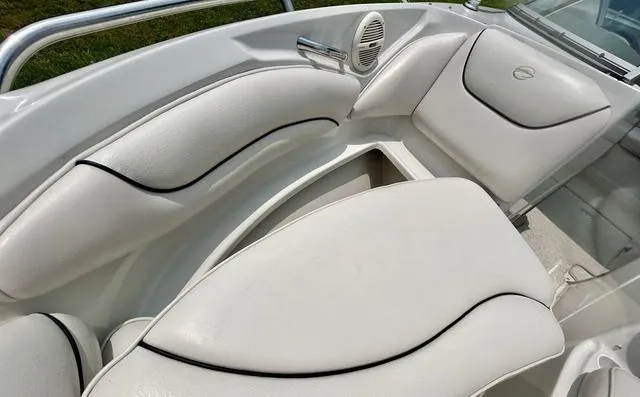 Slide: The Image of 2005 Crownline 216 LS boat interior with white cushioned seating and speaker. - 19