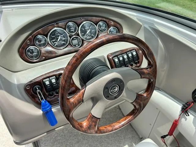 Slide: The Image of 2005 Crownline 216 LS boat dashboard with wood-grain steering wheel and instrument panel. - 27