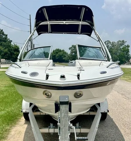 Slide: The Image of 2005 Crownline 216 LS boat on trailer, front view with canopy, parked outdoors. - 5