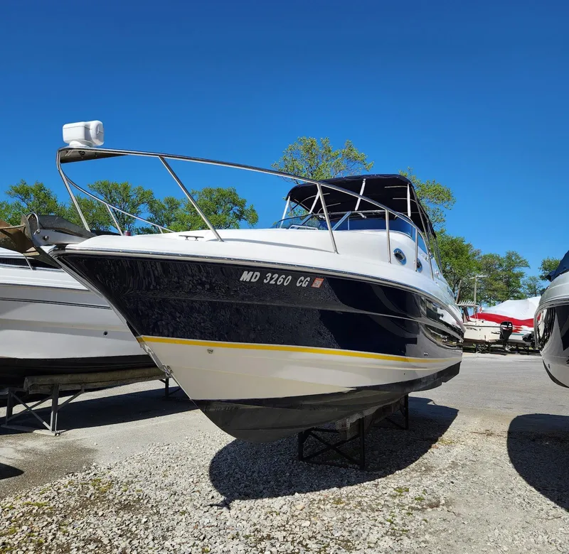Slide: The Image of 2006 Larson Cabrio 260 boat on display under clear blue sky. - 1