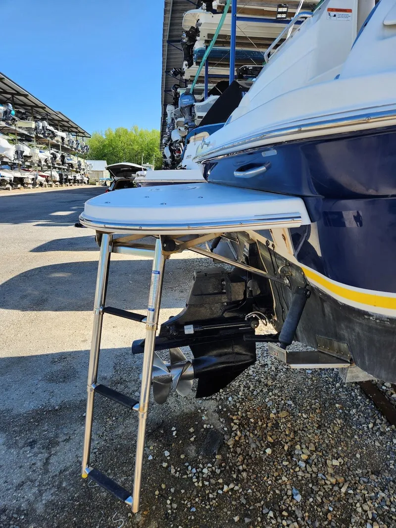 Slide: The Image of 2006 Larson Cabrio 260 boat with swim platform and ladder in storage facility. - 14