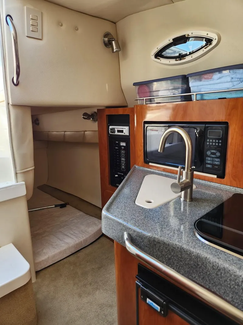 Slide: The Image of 2006 Larson Cabrio 260 interior with kitchenette, sink, and microwave. - 18