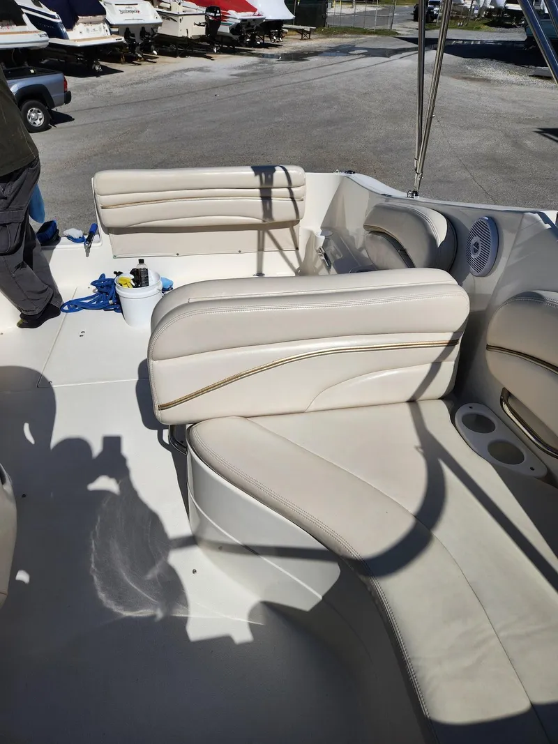 Slide: The Image of 2006 Larson Cabrio 260 boat interior with beige seating and cup holders. - 19