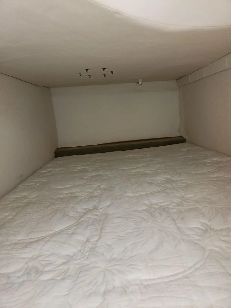 Slide: The Image of Interior cabin of 2006 Larson Cabrio 260 boat with white bedding. - 22