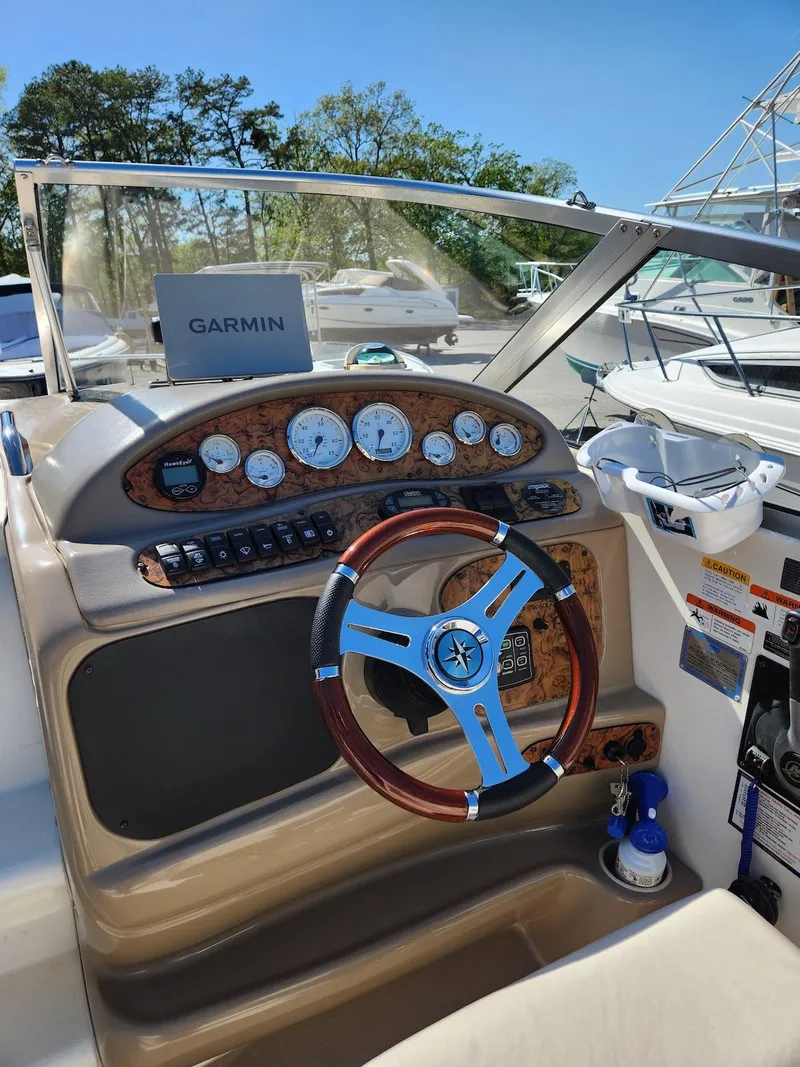 Slide: The Image of 2006 Larson Cabrio 260 boat dashboard with Garmin navigation system and wooden steering wheel. - 26