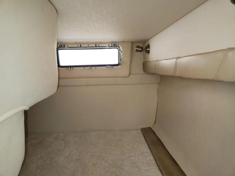 Slide: The Image of 2006 Larson Cabrio 260 cabin interior with beige upholstery and small window. - 29