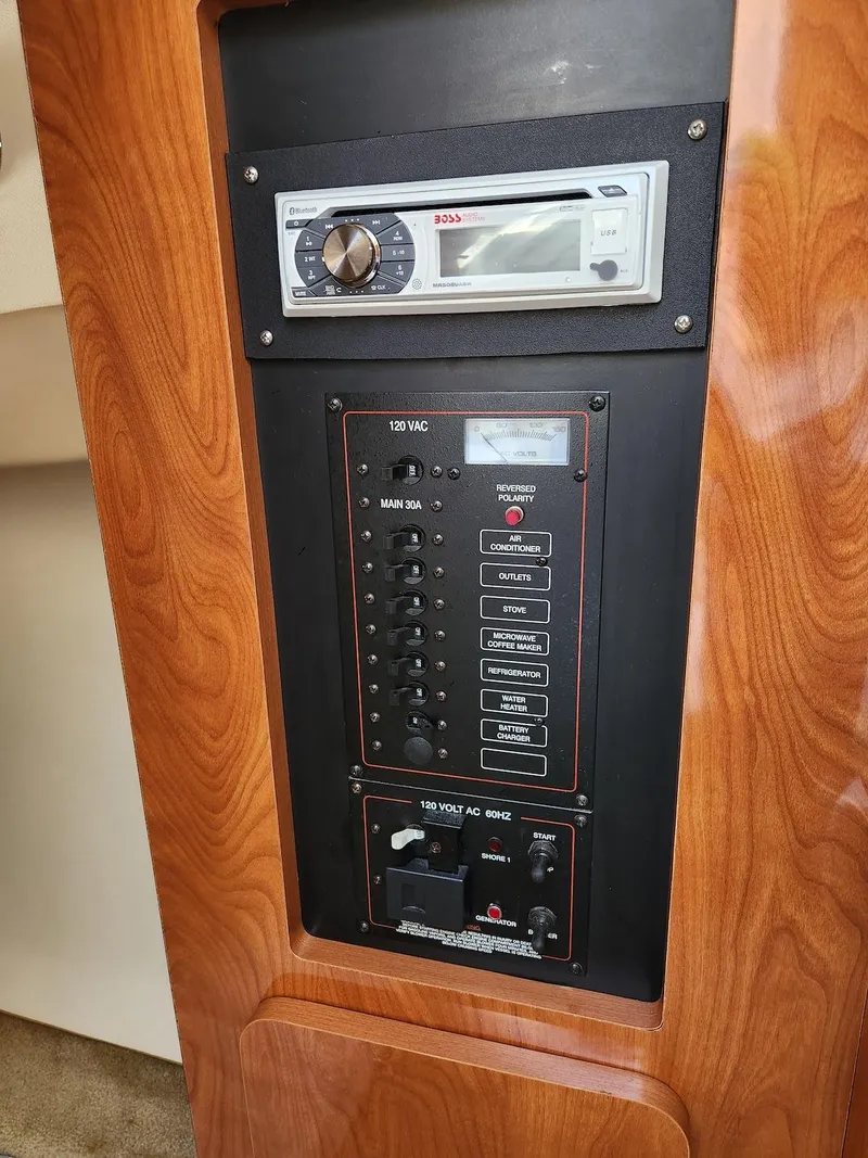 Slide: The Image of 2006 Larson Cabrio 260 control panel with stereo and electrical switches. - 36