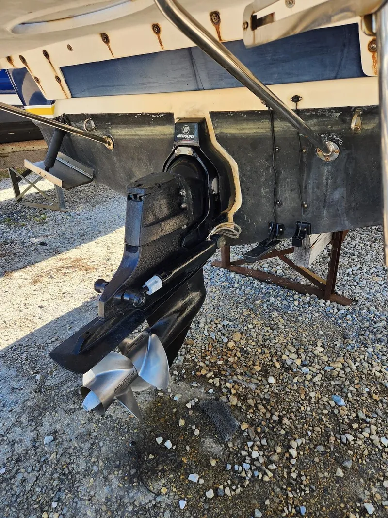 Slide: The Image of 2006 Larson Cabrio 260 boat stern with propeller and outdrive on gravel surface. - 43